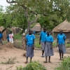 Esther går og snakker med sine veninder på vej hjem fra skole. Om lidt kalder pligterne. Hun skal bade sine søskende og hjælpe sin tante med at lave mad. - Foto: Emmanual Museruka