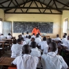 Et typisk klasseværelse i Uganda. Eleverne i skoleuniformer sidder ved pulte med deres skrivehæfter. – Foto: Heidi Brehm